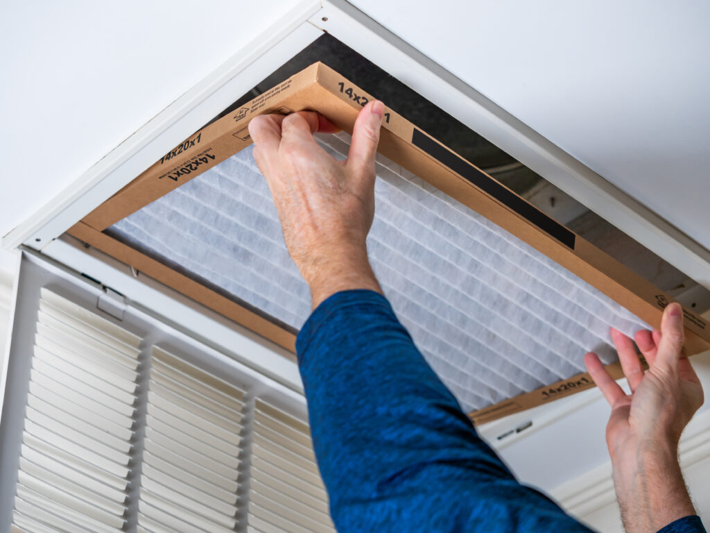 HVAC technician replacing a home air filter in Glendora