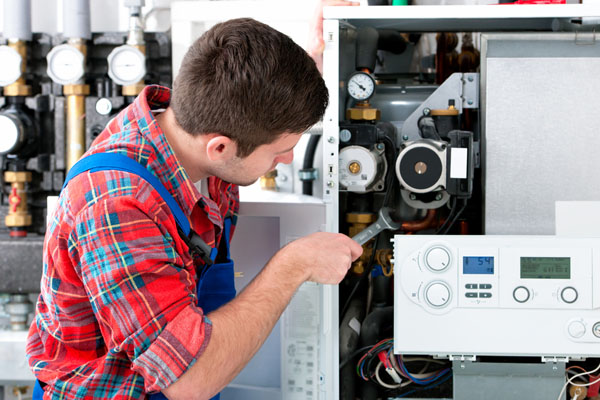 Heating technician repairing boiler controls in Glendora