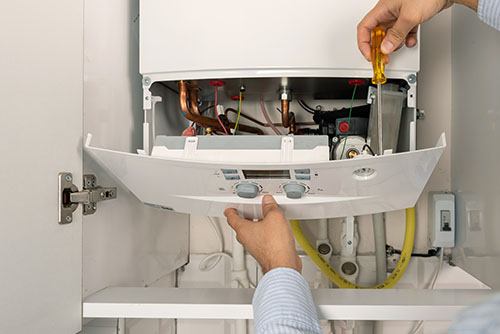 Heating technician repairing a residential boiler in Glendora