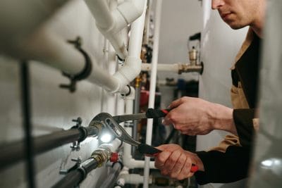 Technician inspecting commercial plumbing pipes in Glendora