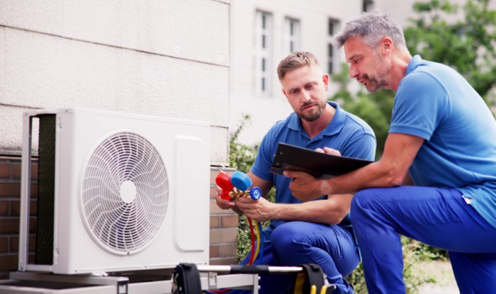 HVAC technicians installing an outdoor air conditioning unit in Glendora