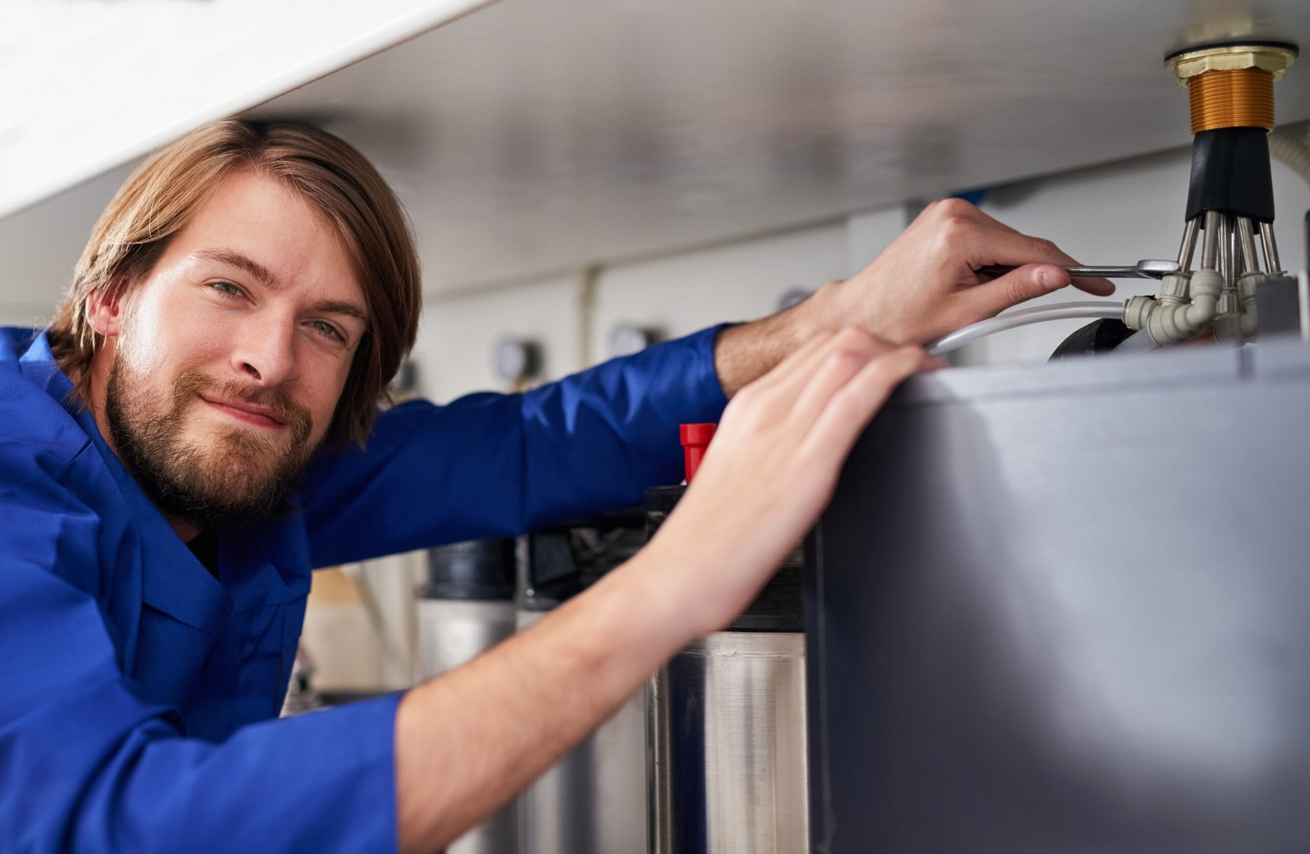 Technician servicing a residential water heater tank in Glendora